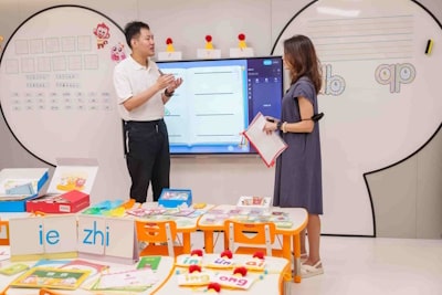 image of two asian teachers discussing in the front of a classroom for young kids