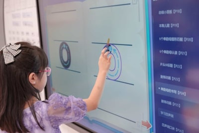 image of young child touching TV screen to solve a problem for class