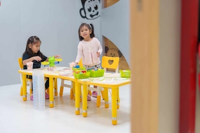 image of two kids sitting on their desks, playing with toys